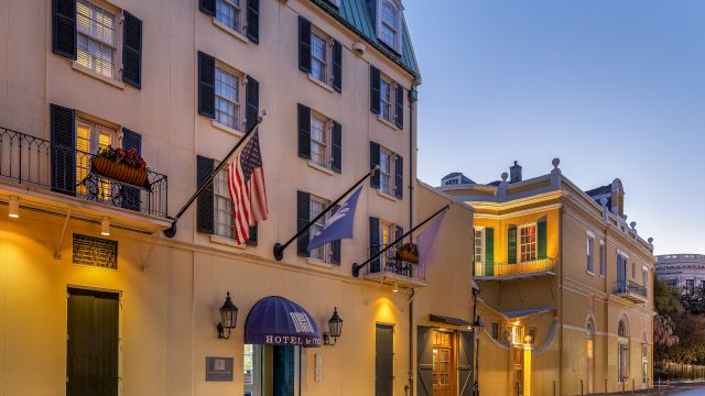 A hotel building with balconies, flags, and lights
