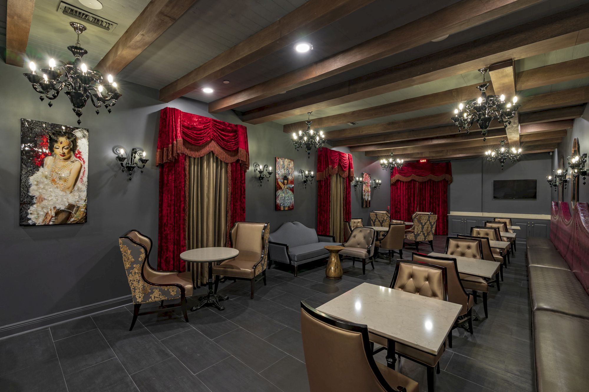 A luxurious lounge with tables, chairs, and artwork.